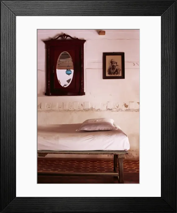 Framed Print : Interior detail of day bed with old photograph of a Framed Print : Interior detail of day bed with old photograph of a