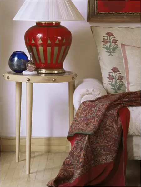 Side table and hand blown glass based lamp beside sofa