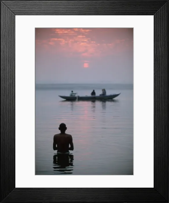 Framed Print : Boat passing a man standing in the holy river Framed Print : Boat passing a man standing in the holy river