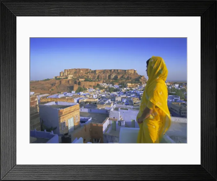 Framed Print : A woman in a yellow sari looking out over the Blue city and fort Framed Print : A woman in a yellow sari looking out over the Blue city and fort