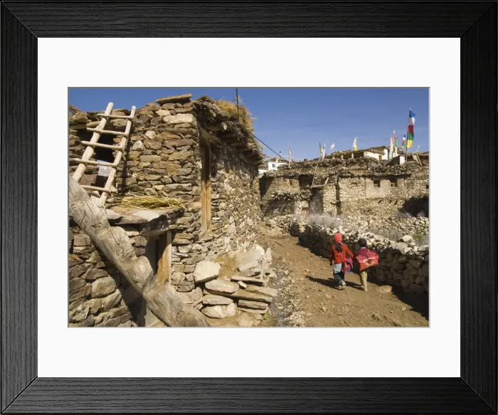 Framed Print : Two schoolchildren and typical stone houses on village street Framed Print : Two schoolchildren and typical stone houses on village street