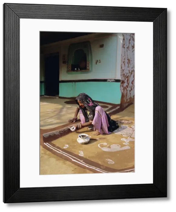 Framed Print : Woman painting the wall of a village house Framed Print : Woman painting the wall of a village house
