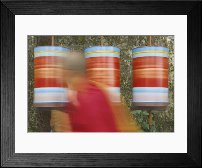 Framed Print : Buddhist monk passing prayer wheels Framed Print : Buddhist monk passing prayer wheels