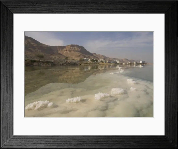 Framed Print : Sea and salt formations with hotels and desert cliffs beyond Framed Print : Sea and salt formations with hotels and desert cliffs beyond