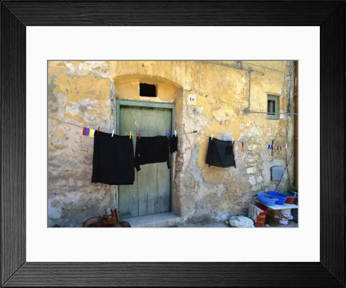 Framed Print : Clothes on a washing line outside an old house with Framed Print : Clothes on a washing line outside an old house with