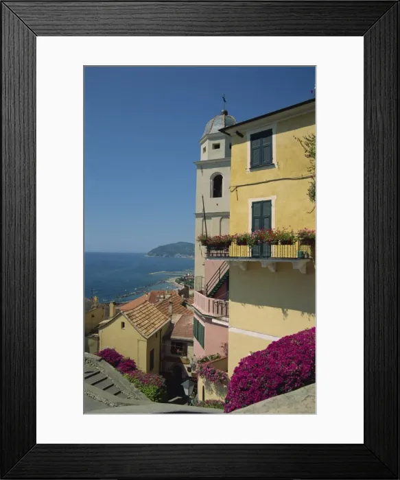 Framed Print : Tower and houses overlooking the coast in the town