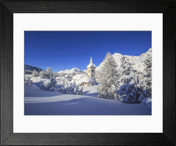 Framed Print : The winter sun illuminates the snowy landscape and the typical church, Maloja, Engadine Framed Print : The winter sun illuminates the snowy landscape and the typical church, Maloja, Engadine