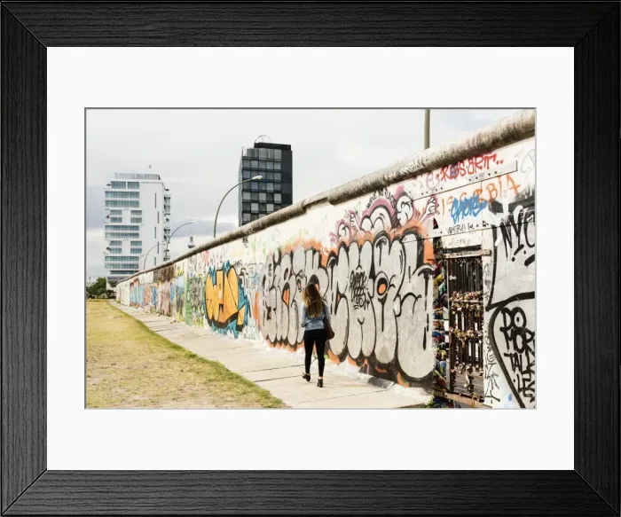 Framed Print : Young woman walking past graffiti on former Berlin Wall, East Side Gallery, Muhlenstrasse Framed Print : Young woman walking past graffiti on former Berlin Wall, East Side Gallery, Muhlenstrasse