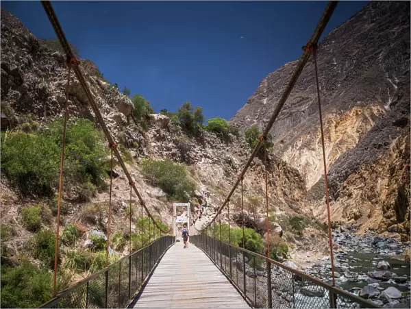 People trekking over Colca River Bridge, Colca Canyon, Peru, South America