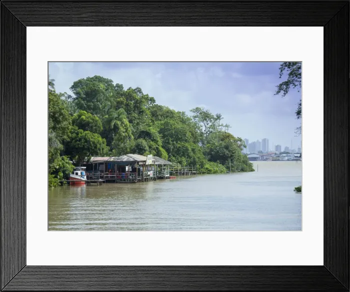 Framed Print : Boats and stilt house on an igarape (flooded creek) in the Brazilian Amazon with Belem city behind