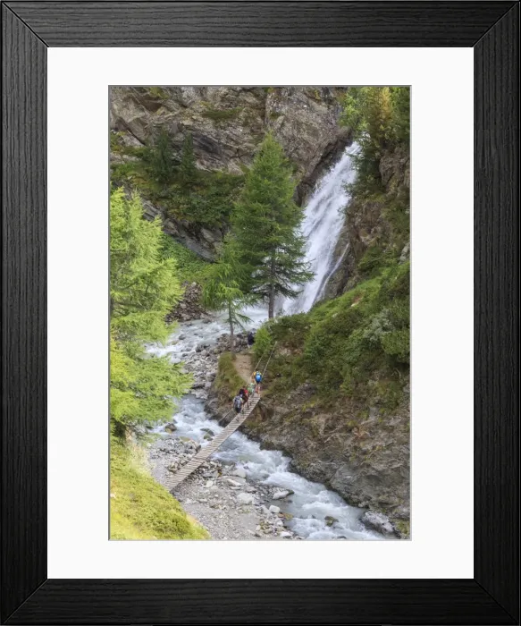 Framed Print : Hikers cross the wooden bridge on a creek in the woods, Minor Valley, High Valtellina Framed Print : Hikers cross the wooden bridge on a creek in the woods, Minor Valley, High Valtellina