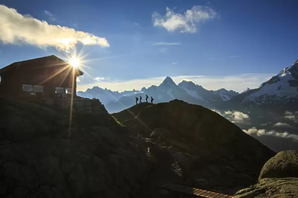 Hikers proceed towards Refuge of Lac de Cheserys with the sun just risen, Chamonix