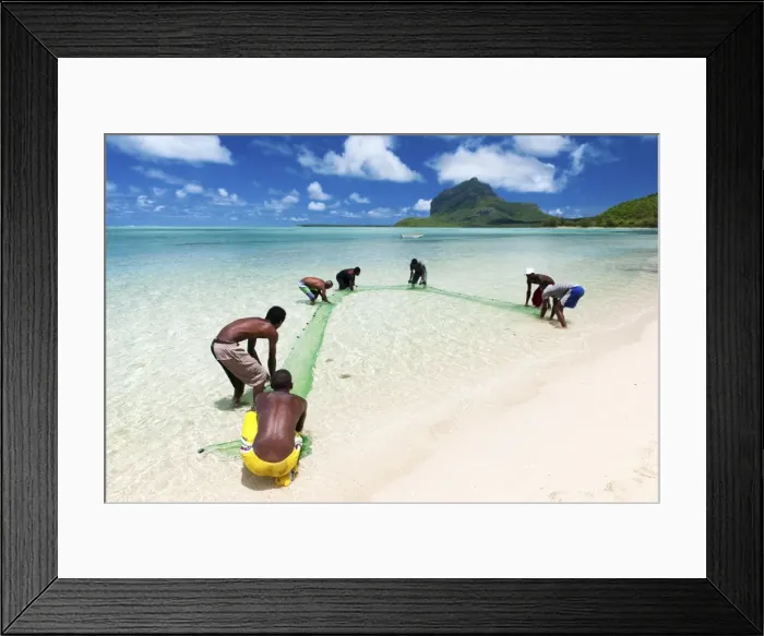 Framed Print : Fisherman on a beach being overlooked by the basaltic monolith, Le Morne, Black River