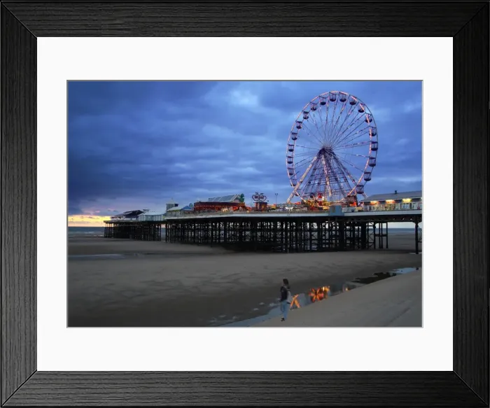 Framed Print : Big wheel and amusements on Central Pier at sunset with young women looking on, Blackpool Framed Print : Big wheel and amusements on Central Pier at sunset with young women looking on, Blackpool