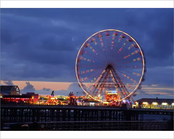 Big wheel and funfair on Central Pier lit at dusk, Blackpool Illuminations, Blackpool