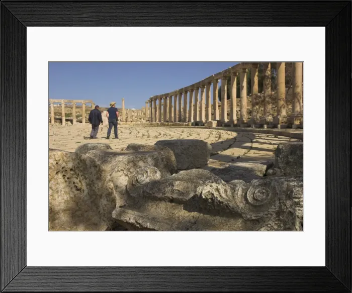 Framed Print : Column capital in foreground and visitors walking in Forum Framed Print : Column capital in foreground and visitors walking in Forum