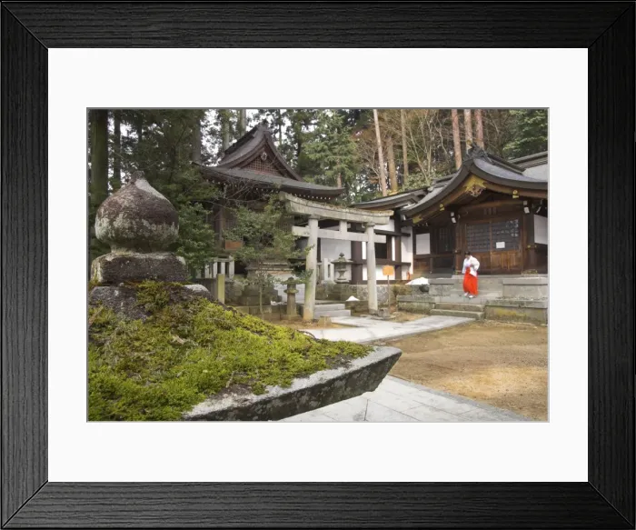 Framed Print : Courtyard with temple buildings and female priest wearing Framed Print : Courtyard with temple buildings and female priest wearing