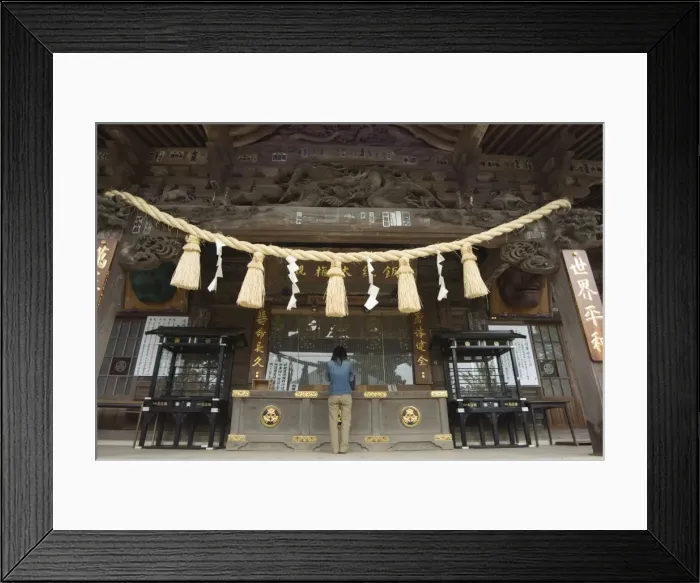 Framed Print : Girl praying at shrine under giant rope Framed Print : Girl praying at shrine under giant rope