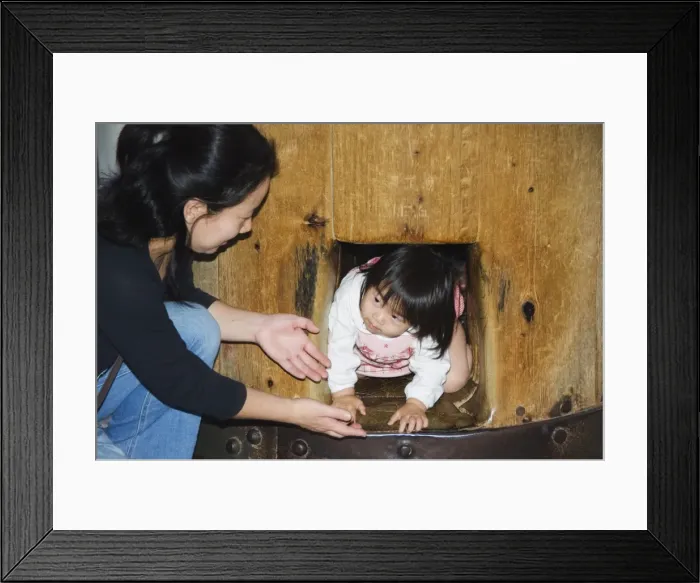 Framed Print : Child crawling though hole in wooden column to reach Nirvana Framed Print : Child crawling though hole in wooden column to reach Nirvana