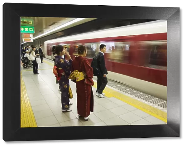 Young women wearing kimono waiting for train to arrive