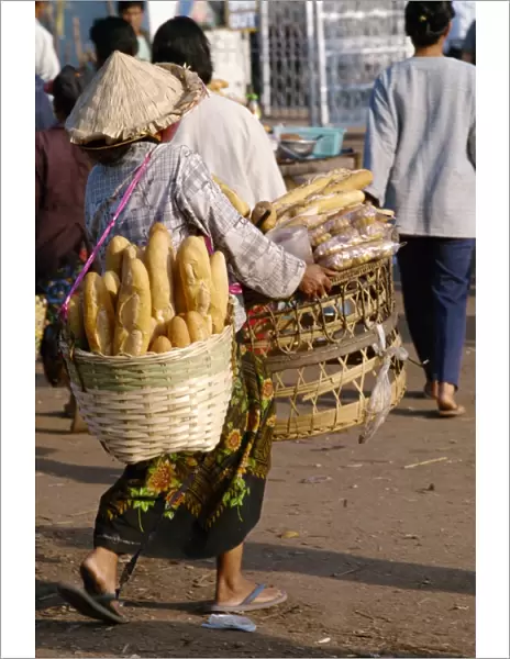 Woman carrying two baskets of French bread in the Talaat