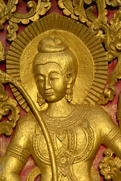 Close up of a figure carved in relif and gilded on