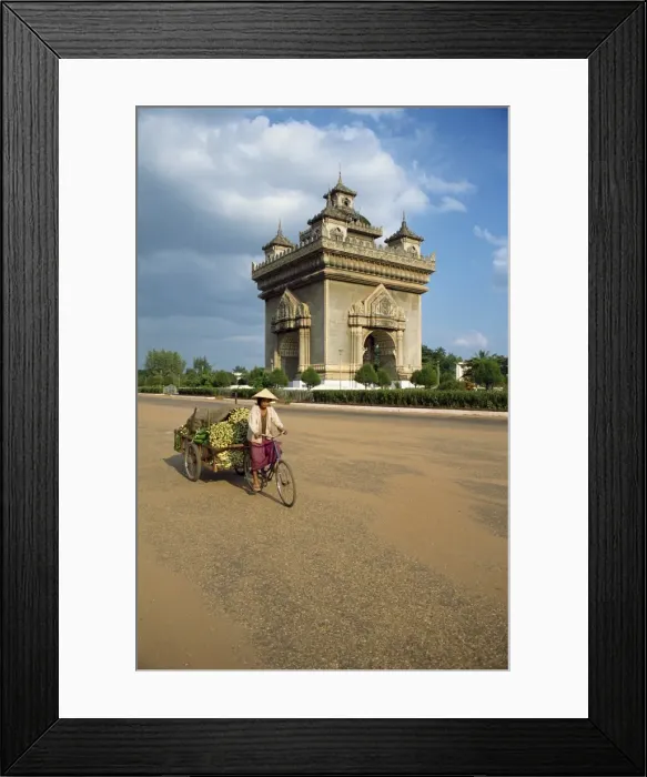 Framed Print : Woman on a bicycle with a trailer rides past the Anousavari Framed Print : Woman on a bicycle with a trailer rides past the Anousavari