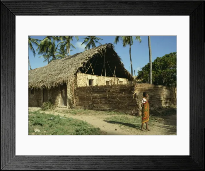 Framed Print : Child stood before traditionally built home Framed Print : Child stood before traditionally built home