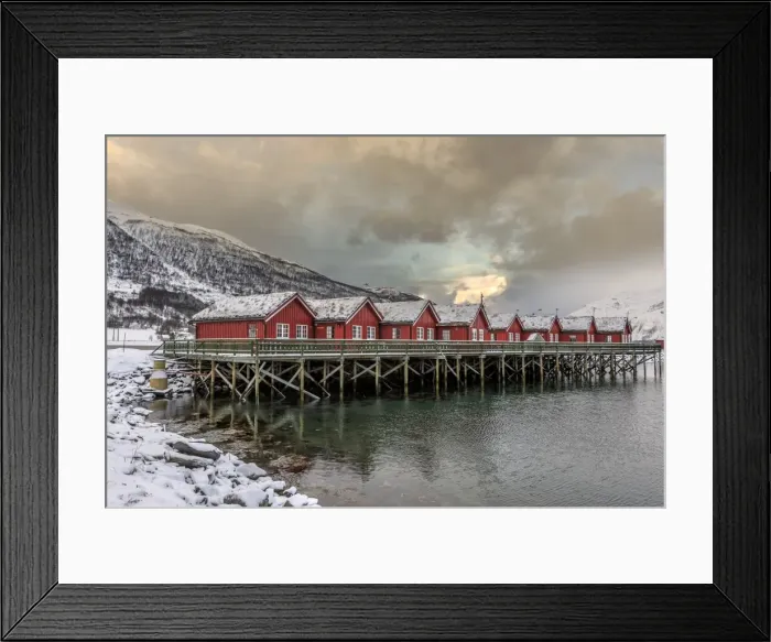 Framed Print : Typical red wooden huts of fishermen in the snowy and icy landscape of Lyngen Alps Framed Print : Typical red wooden huts of fishermen in the snowy and icy landscape of Lyngen Alps