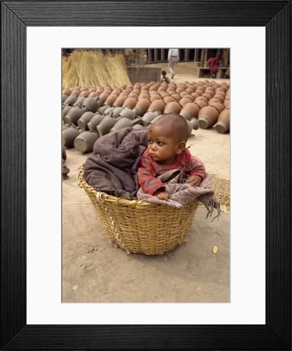 Framed Print : Baby in a wicker basket at Bhaktapur in Nepal Framed Print : Baby in a wicker basket at Bhaktapur in Nepal