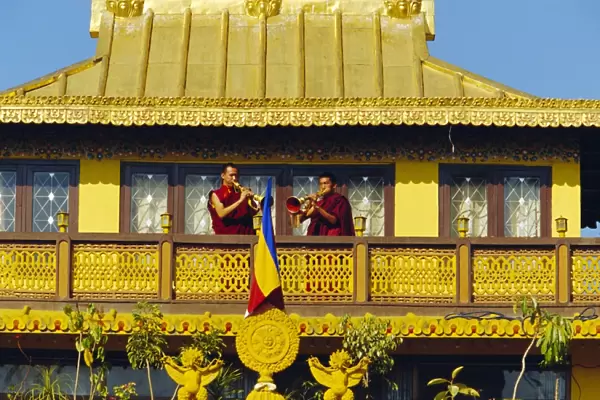 Monks blowing Tibetan horns on the roof the Sakyapa gompa