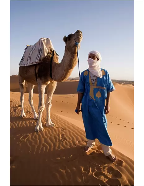 Berber man standing with his camel