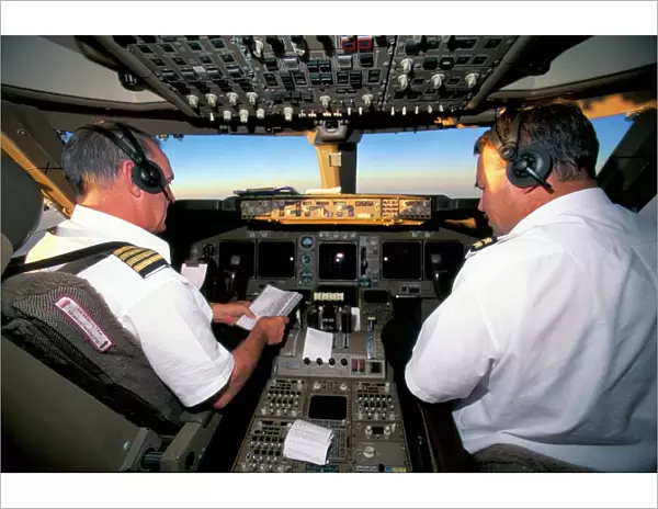 Pilots on flight deck of Jumbo Boeing 747 of Air New Zealand with sunrise ahead