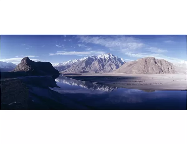 Panorama of mountains reflected in the water of the Indus River