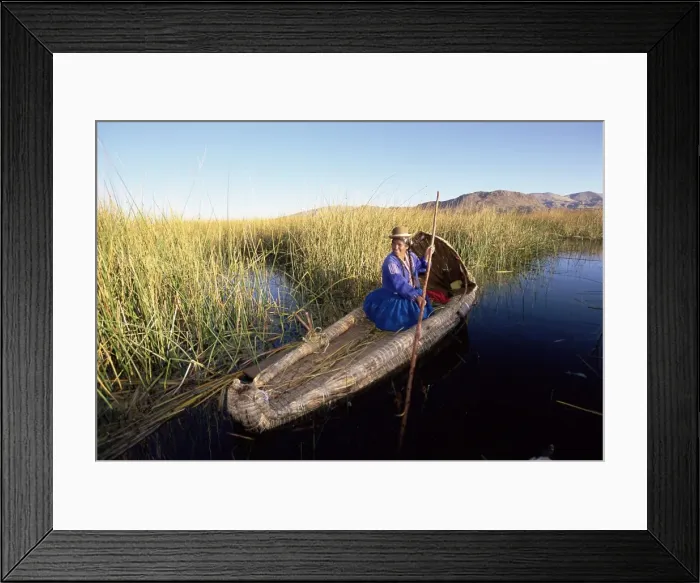 Framed Print : A Uros Indian woman in a traditional reed boat