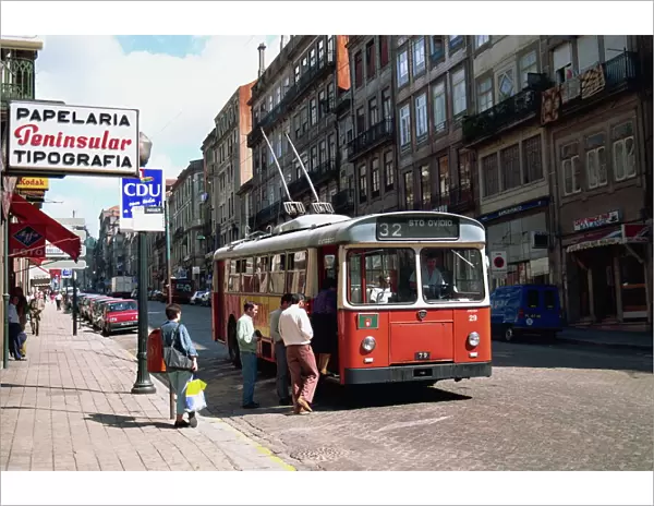 Street scene of people getting on a trolley bus in