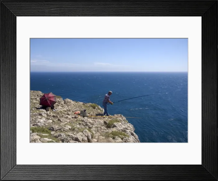 Framed Print : A man fishes from the tall cliffs of Cabo de Sao Vicente