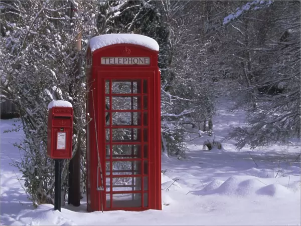 Red letterbox and telephone box in the snow