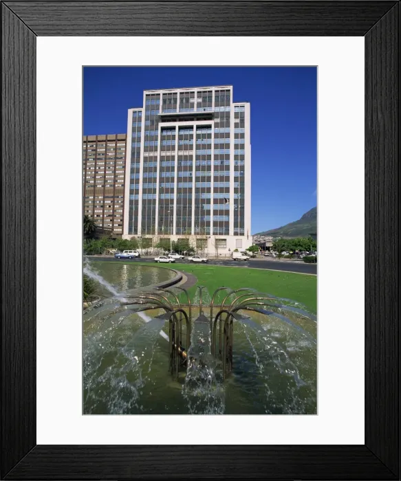 Framed Print : Water fountain on round-a-bout with an office building behind Framed Print : Water fountain on round-a-bout with an office building behind