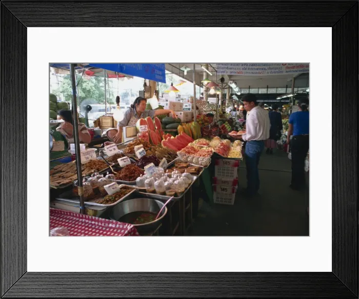 Framed Print : A shopkeeper pointing at fruit on one of the food stalls Framed Print : A shopkeeper pointing at fruit on one of the food stalls