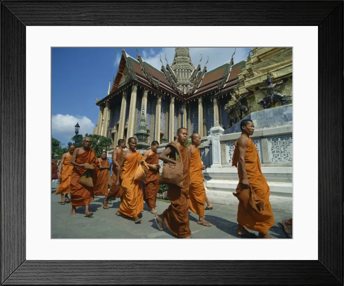 Framed Print : Monks in saffron robes walk past a temple in Bangkok Framed Print : Monks in saffron robes walk past a temple in Bangkok