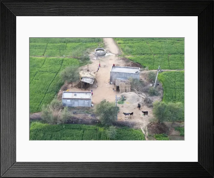 Framed Print : Man sitting on house roof in tiny agricultural hamlet amidst fields of vegetables Framed Print : Man sitting on house roof in tiny agricultural hamlet amidst fields of vegetables