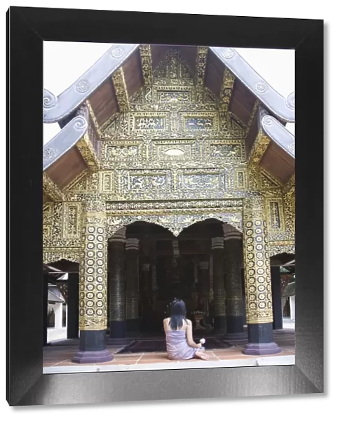 Thai woman praying in Buddhist temple