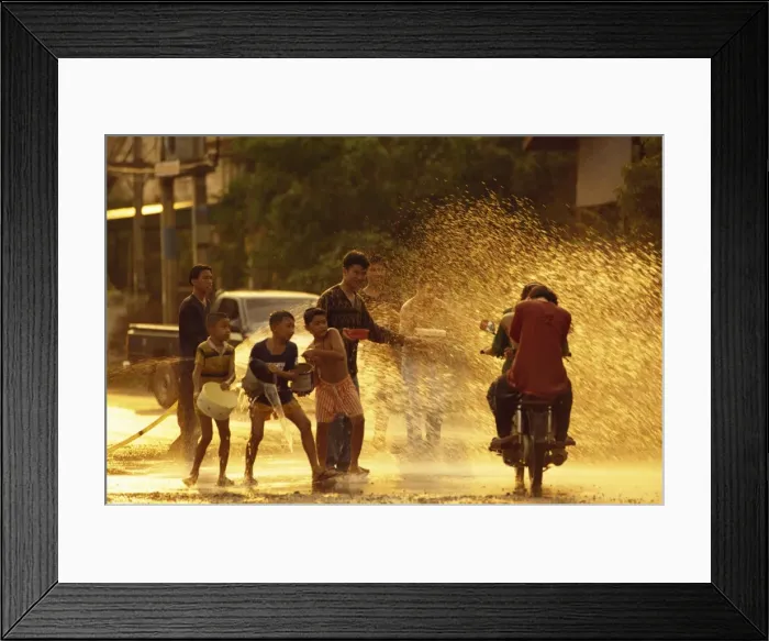 Framed Print : People on a motorbike being showered with water by Framed Print : People on a motorbike being showered with water by