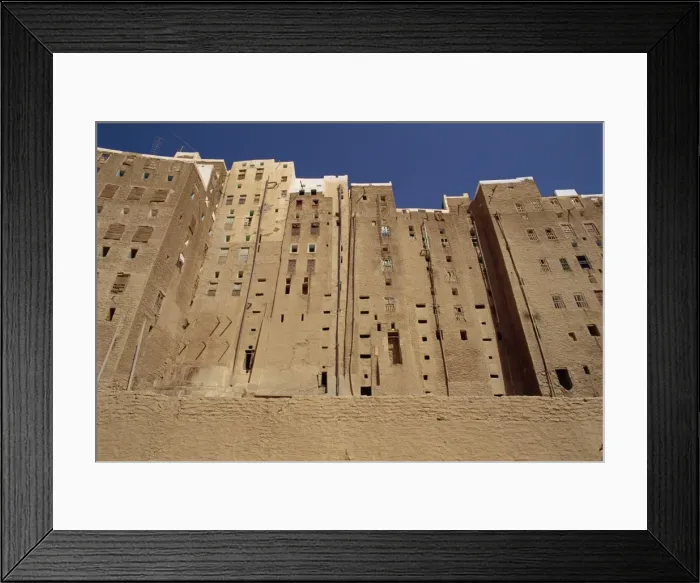 Framed Print : Backs of tall mud brick houses showing holes in the wall for toilets