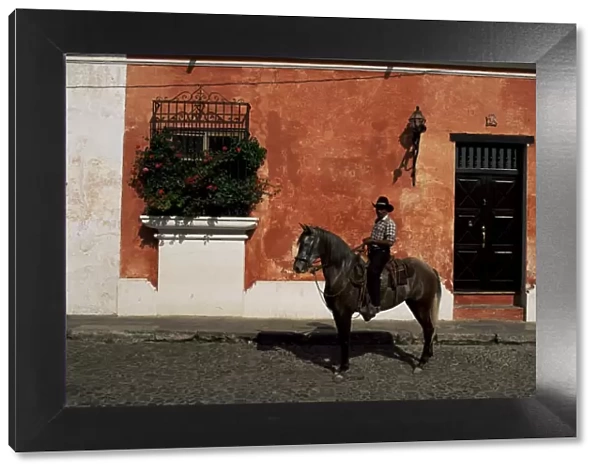 Man on horse in front of a typical painted wall