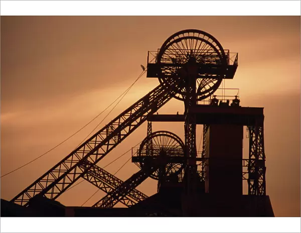 Coalmine pithead silhouetted at dusk