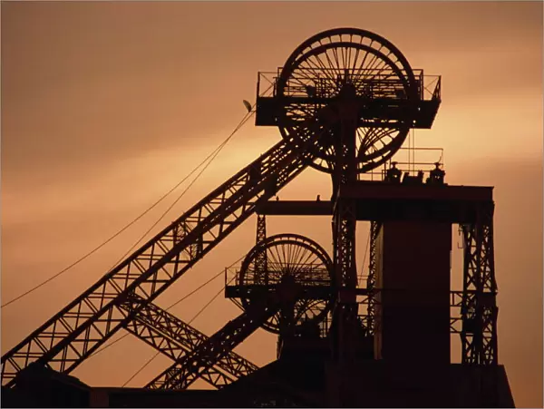Coalmine pithead silhouetted at dusk