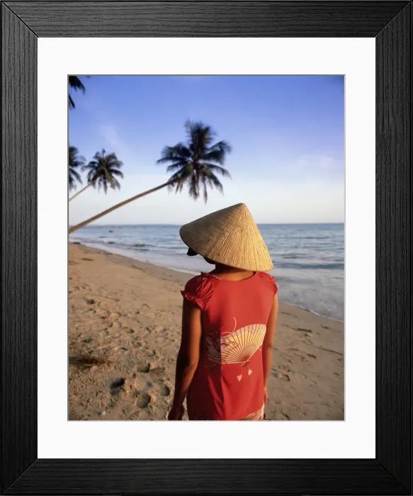 Framed Print : Woman in conical hat walking along the beach Framed Print : Woman in conical hat walking along the beach