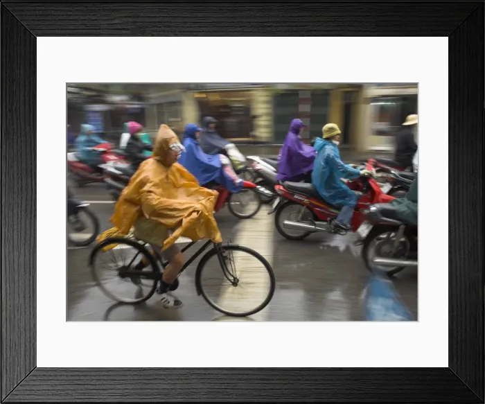 Framed Print : People riding bikes and mopeds in the rain wearing nylon protection Framed Print : People riding bikes and mopeds in the rain wearing nylon protection